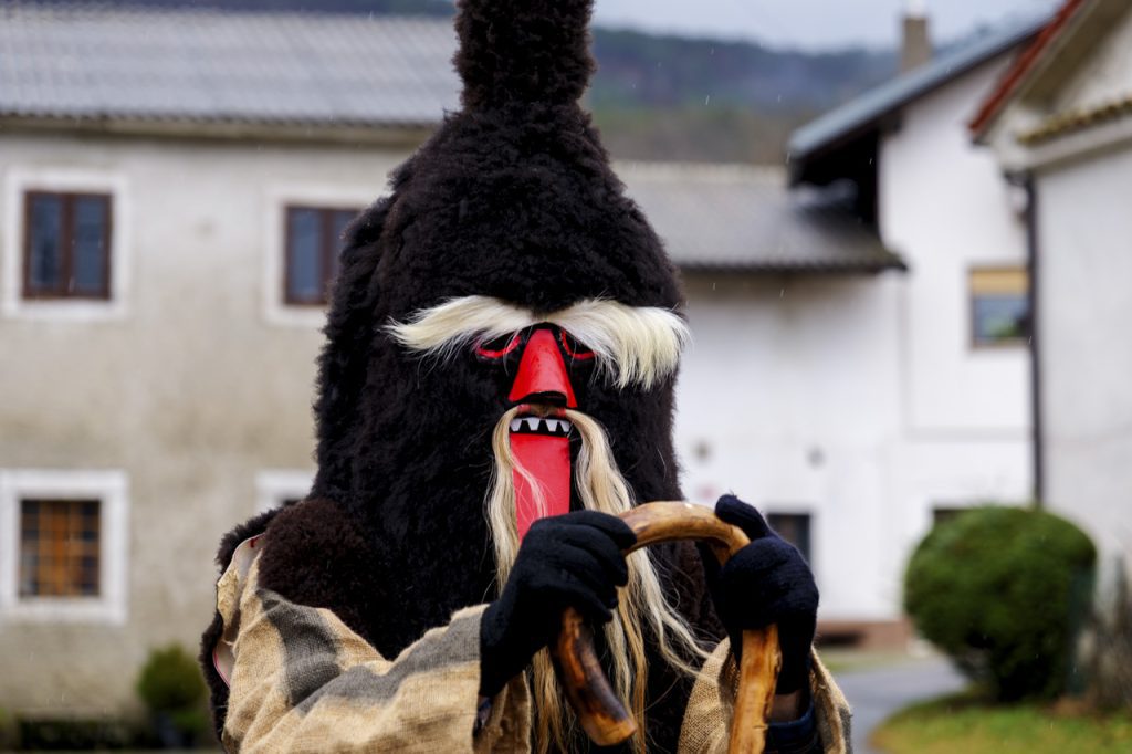 Maschere tradizionali del carnevale sloveno: Vrbišće šjme 6 Il cacciatore nero "Črn louc" col suo bastone ricurvo.