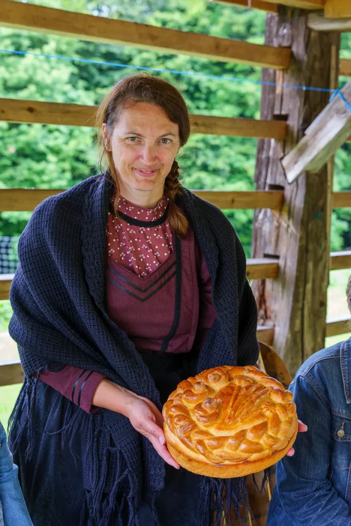 Cosa vedere in Dolenjska: itinerario di 3 giorni tra natura, storia e ospitalità 9 Tanja Vesel, in abiti tradizionali della Dolenjska, col praznični kruh, il pane delle feste.